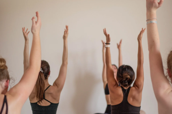 Group raising arms together in a Body Alchemy class